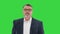 Successful businessman walking fast looking at watch on a Green Screen, Chroma Key.