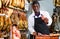 Successful butcher shop owner recommending to taste delicious iberian ham