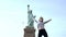 Successful Caucasian female student jumping high with joy and cheer celebrating success at Statue of Liberty slow motion