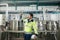 Successful of caucasian technician engineer man in safety uniform standing in pipeline, boiler tank laboratory at beverage