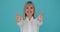 Successful Caucasian Woman Giving Thumbs Up on Blue Background
