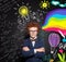 Successful clever child boy with ginger hair, glasses and crossed arms on lightbulb, science and arts scetch background.