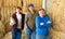 Successful elderly dairy farm owner with adult son and teen grandson standing in hayloft