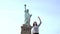 Successful European female freelance worker jumping high with joy enjoying good living at Statue of Liberty slow motion.