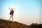 Successful girl backpacker, standing on the hill with open arms