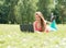 Successful girl online. Beautiful young woman with notebook in the park. Happy student lying on grass with laptop. Outdoor.