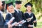 successful graduated students in capes and hats holding