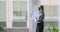 Successful happy mature businesswoman standing looking through office window