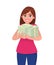 Successful happy young business woman holding cash / money / currency / banknote bundle in hands. Business and finance concept.