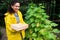 Successful horticulturist, African American farmer with a wooden crate, harvesting cucumbers in her own organic eco farm