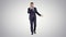 Successful man in suit speaks on phone and walks on gradient background.