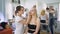 Successful, multi-beauty salon. Several professionals work with their clients. In the frame of an attractive blond woman