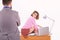 A successful office secretary. Young business secretary woman sitting on desktop against man boss. Company owner looking