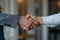 A successful partnership handshake between a businessman and his colleague in a corporate office,