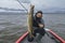 Successful pike fishing. Happy fisherman hold huge muskie fish