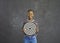 Successful positive african american woman holding a dart board standing on a gray background.