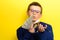 Successful and rich child taking a selfie with money, portrait of a boy in a suit on a yellow background