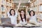 Successful schoolgirls raise hands in the library