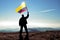 Successful silhouette man winner waving Colombian flag on top of the mountain