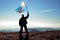 Successful silhouette man winner waving Democratic Republic of Congo flag on top of the mountain