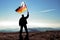 Successful silhouette man winner waving German flag on top of the mountain