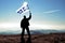 Successful silhouette man winner waving Martinique flag on top of the mountain