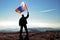 Successful silhouette man winner waving Mongolia flag on top of the mountain