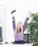 Successful young blonde businesswoman, victory gesture, hands up, smiling at office