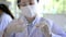 Successful young female medical researcher and scientist wearing labcoat standing in laboratory while working on