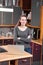 Successful young woman standing with arms crossed posing in kitchen