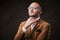 Successfull bald businessman posing in a studio wearing stylish velvet jacket, white shirt and glasses