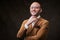 Successfull bald businessman posing in a studio wearing stylish velvet jacket, white shirt and glasses