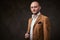 Successfull bald businessman posing in a studio wearing stylish velvet jacket, white shirt and glasses