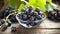 Succulent Delights: A Captivating Display of Black Grapes in a Glass Bowl on a Wooden Table