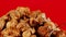 Succulent pieces of meat in yellow plate. Appetizing seasoned pile of meat spinning on red background. Close up.