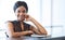 Sucessful black businesswoman looking into camera while seated at counter