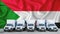 Sudan flag in the background. Five new white trucks are parked in the parking lot. Truck, transport, freight transport. Freight