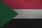 Sudan flag depicted in paint colors on old brushed metal plate or wall closeup. Textured banner on rough background