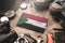 Sudan Flag Between Traveler`s Accessories on Old Vintage Map. Tourist Destination Concept