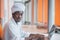 Sudanese business man in traditional outfit using mobile phone in office