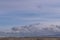 The Sudetes seen from a distance with the peaks partially covered with a layer of dense clouds.