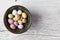 Sugar coated speckled easter eggs in ceramic bowl on white