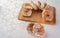 Sugar-coated sweet cookies placed on a polished board on a table with white tablecloth, selective focus