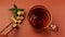 Sugar cubes added into tea glass on brown background