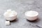 Sugar cubes and granulated sugar in white bowls on a table