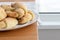 Sugar-frosted croissants from a cottage cheese dough on a white plate on a wooden table with linen tablecloth. Tea snack