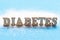 Sugar and inscription Diabetes from wooden letters front view.