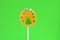 Sugar marmalade candy on a stick on a green background