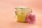 Sugar paste for depilation. Shugaring. Removing hair. Cosmetics. Honey in jar with flower on Living Coral background