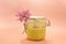 Sugar paste for depilation. Shugaring. Removing hair. Cosmetics. Honey in jar with flower on Living Coral background